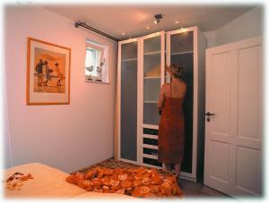 a woman in a dress standing in a room at Appartmentvermittlung Sommerwind in Binz