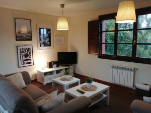 a living room with a couch and a tv at La Casa Roja Asturias in Hontoria