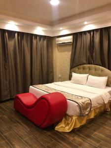 una camera con un letto con un sedile rosso a cuore di ريحانة الورود a Abha