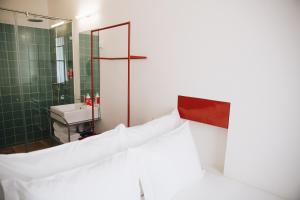 a bathroom with a white bed and a sink at Esqina Cosmopolitan Lodge in Lisbon
