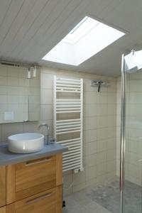 een badkamer met een wastafel en een dakraam bij La Farigoule in Montbrun-les-Bains