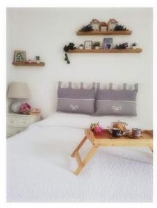 a bedroom with a bed with a table and shelves at DIMORA MELISSA in Colà di Lazise