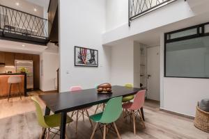 a dining room with a black table and colorful chairs at Ayenda La Joya in Mexico City
