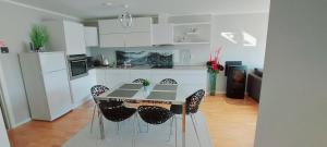 a kitchen with a table and chairs in a room at Bjørnestrand Fjordside View in Bergen +36 photos
