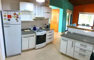 a kitchen with white appliances and a white refrigerator at Casa Penelope Pinamar in Pinamar