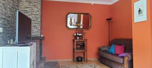 a living room with a couch and a mirror at Casa da Oliveira in Milhão