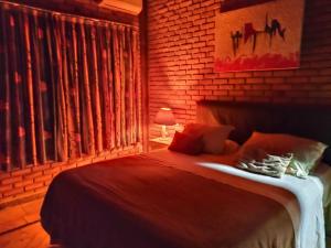 ein Schlafzimmer mit einem großen Bett und einer Ziegelwand in der Unterkunft Charmosa casa com churrasq na praia de Camburi in São Sebastião + 12 Fotos