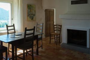 een eetkamer met een tafel en stoelen en een open haard bij La Farigoule in Montbrun-les-Bains