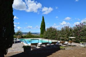einen Pool mit Stühlen im Hof in der Unterkunft Villa San Sebastiano Montalcino in Montalcino