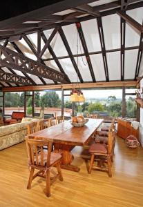 Portón de Ovejas SISGA para 24 personas في Chocontá: طاولة خشبية كبيرة في غرفة مع كراسي