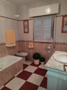 a bathroom with a tub and a toilet and a sink at Casa de la Gloria in Baños de la Encina +13 photos