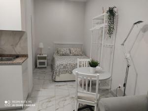 1 dormitorio con 1 cama, mesa y sillas en Estudio 2 personas Wifi fácil acceso centro de Madrid, en Madrid