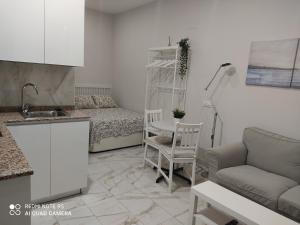 cocina y sala de estar con sofá y mesa en Estudio 2 personas Wifi fácil acceso centro de Madrid, en Madrid