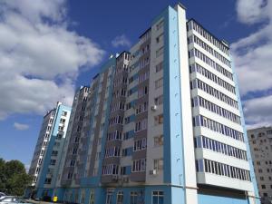 a tall apartment building with a blue at Стильна квартира в новому будинку, поряд центр та р. Дніпро in Cherkasy