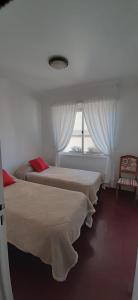 zwei Betten in einem Zimmer mit Fenster in der Unterkunft El Shaddai in San Salvador de Jujuy