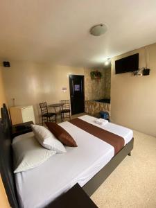 um quarto com uma cama grande e uma mesa em Hostal Bellagio em Guayaquil