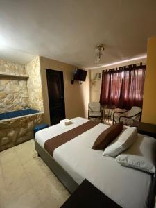 a bedroom with a large bed and a living room at Hostal Bellagio in Guayaquil