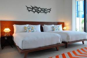 a bedroom with two large beds and two lamps at Escalera Al Cielo in Tulum