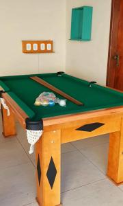 a green pool table with two cuesticks on it at Varandas do Arraial- Hostel in Arraial do Cabo