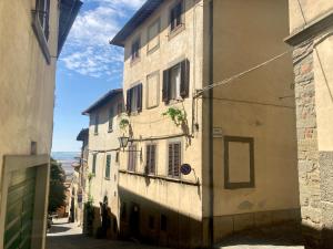 um beco entre dois edifícios numa rua em Casa Vacanze Beppina Cortona em Cortona