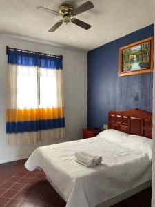 a bedroom with a bed and a ceiling fan at Casa Refugio Budget House 8 Rooms & 9 Bathrooms in Oaxaca City