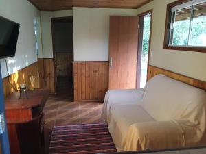 une chambre avec un lit, un bureau et une télévision dans l'établissement Casa Vista do Vale, à Visconde de Mauá