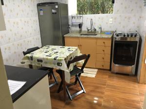 a small kitchen with a table and a refrigerator at Casa Vista do Vale in Visconde De Maua