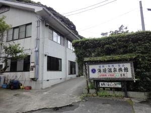 a white building with a sign in front of it at 湯迫温泉旅館 in Ōda