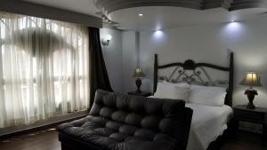 a bedroom with a bed and a couch at Hotel Hacienda los Narcisos in San Juan de los Lagos