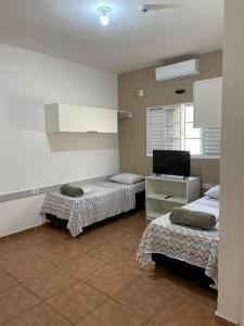 a room with two beds and a tv in it at Hotel 7 in Três Lagoas
