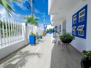 a balcony with potted plants and a white fence at White Coral ApartaSuites in San Andrés