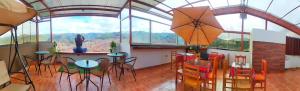a room with a table and chairs and windows at Casa Mirador guesthouse in Cusco