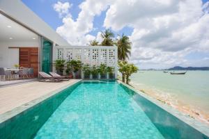 a swimming pool with a view of the ocean at Fisherman Way Beach Villa in Rawai Beach