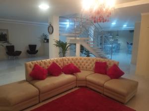 uma sala de estar com um sofá castanho com almofadas vermelhas em Pousada Cavalero em Penha