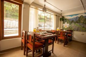 Hostal La Payacha في ماتشو بيتشو: غرفة طعام مع طاولة وكراسي خشبية