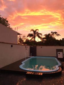 a swimming pool with a sunset in the background at Bela casa, com internet, piscina e churrasqueira para descansar e desfrutar, dias de paz in Barra Velha