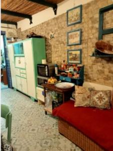 een keuken met een koelkast en een rode bank bij In Laguna ...tra Sacro e Profano in Marceddi