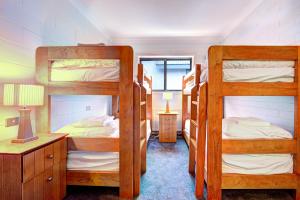 フォールズ・クリークにあるSnow Ski Apartments 40の二段ベッド3台とデスクが備わる客室です。