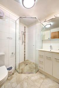 ein Bad mit einer Glasdusche und einem WC in der Unterkunft Snow Ski Apartments 40 in Falls Creek