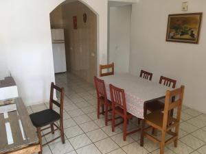 a dining room with a table and chairs and a kitchen at Casa com varanda próximo da Natureza in Foz do Iguaçu