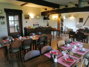 a restaurant with wooden tables and chairs and a kitchen at B&B Ter Castaigne in Koekelare