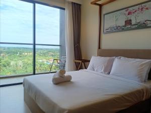 a bedroom with a bed with a stuffed animal on it at Timurbay Lavender Homestay in Kampung Sungai Karang +10 photos