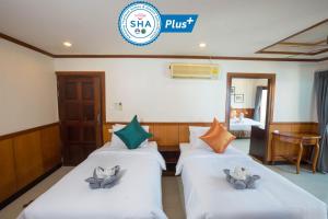 a hotel room with two beds and a sign that reads shahi plus at Sunrise Resort- Koh Phangan - SHA Extra Plus in Haad Rin