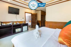 a hotel room with a bed and a flat screen tv at Sunrise Resort- Koh Phangan - SHA Extra Plus in Haad Rin