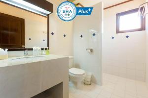 a white bathroom with a toilet and a sink at Sunrise Resort- Koh Phangan - SHA Extra Plus in Haad Rin