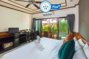 Sunrise Resort- Koh Phangan - SHA Extra Plus في هاد رين: غرفة نوم بسرير وتلفزيون ومكتب