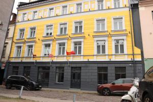 a yellow building with american flags in front of it at Old Riga Plaza Hotel in Rīga