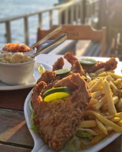 a plate of food with fried chicken and french fries at Flat Sol Victoria Marina Vista Mar in Salvador +8 photos