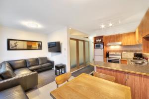 un soggiorno e una cucina con divano e tavolo di Snow Ski Apartments 07 a Falls Creek