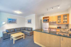 a kitchen and living room with a couch and a table at Snow Ski Apartments 09 in Falls Creek